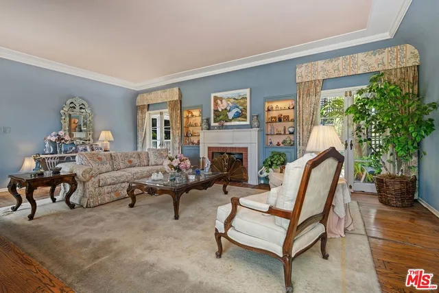 a living room with furniture a fireplace and a potted plant