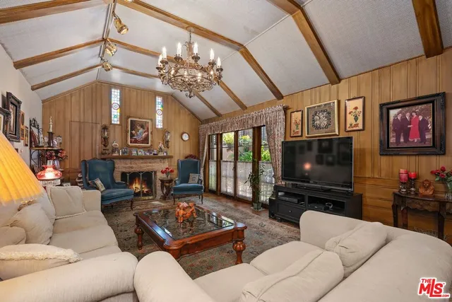a living room with furniture a flat screen tv and a chandelier