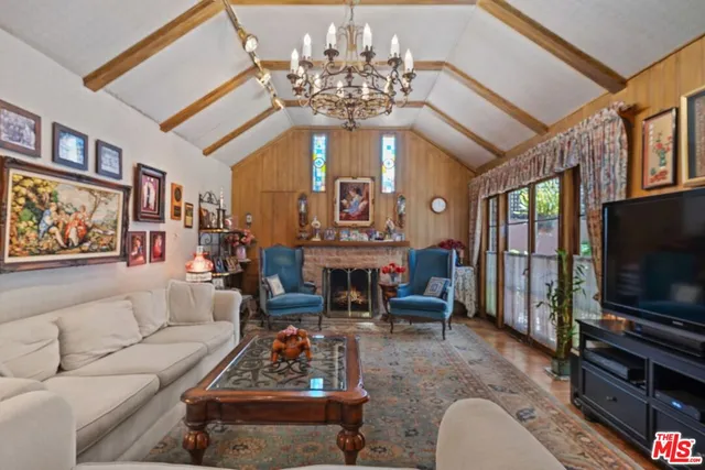 a living room with furniture a chandelier and a flat screen tv