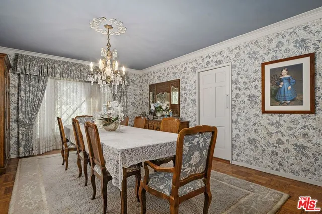 a dining room with furniture a chandelier and wooden floor