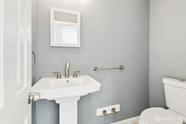 a bathroom with a sink a toilet and a mirror