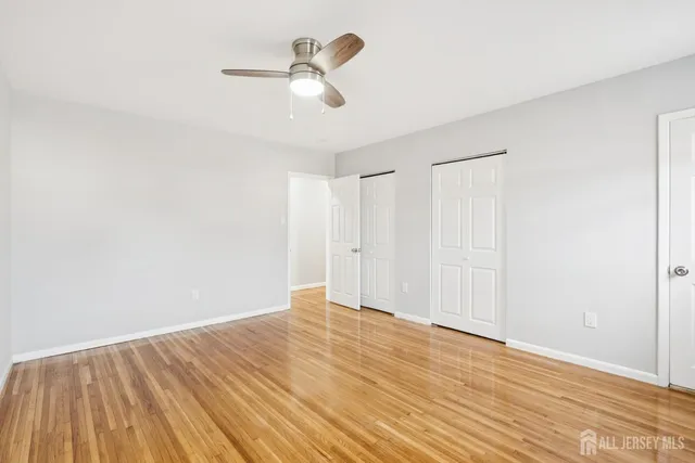 a view of room with wooden floor and ceiling fan