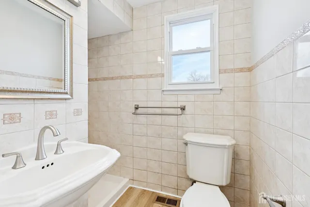a bathroom with a sink mirror and toilet