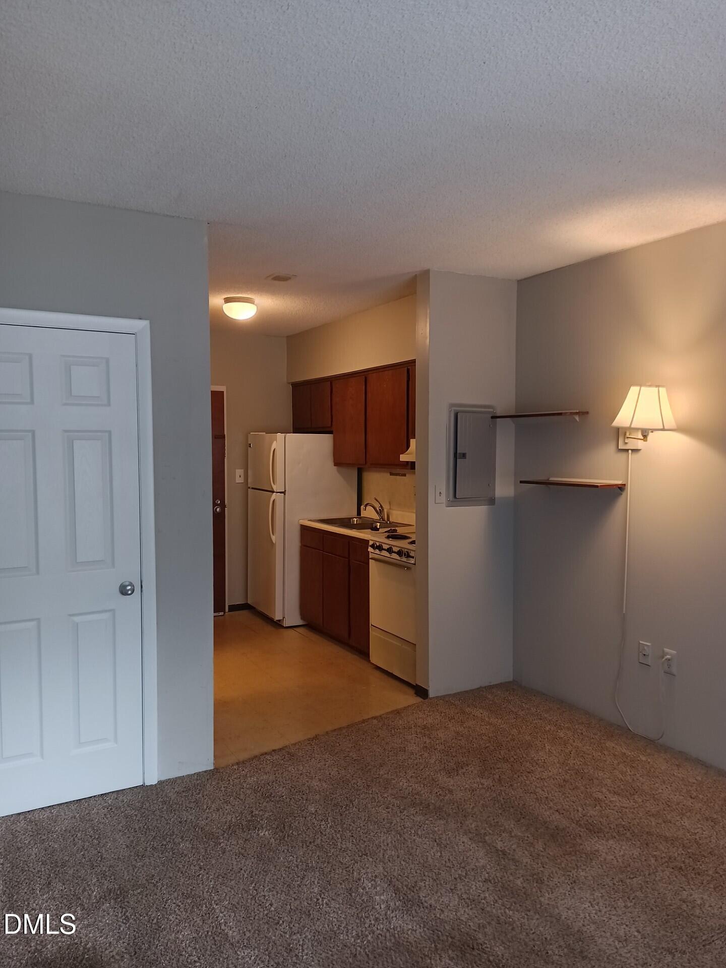 4700 Westgrove Street, Unit 101 Raleigh, NC 27606 - Photo 3 of 5 a kitchen with stainless steel appliances a refrigerator and a stove top oven