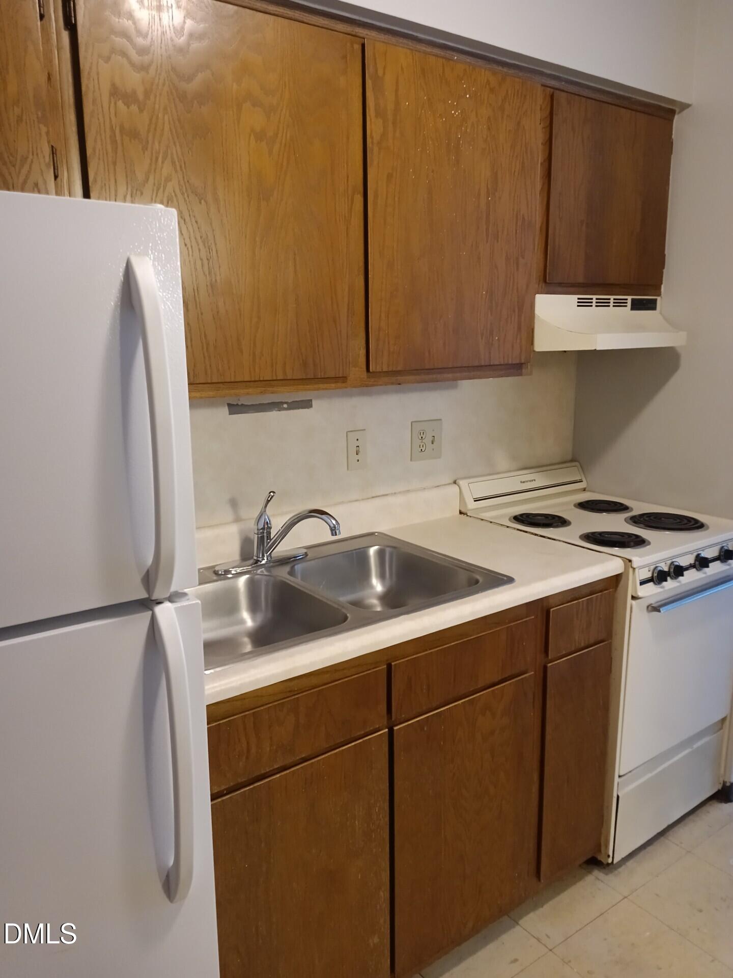 4700 Westgrove Street, Unit 101 Raleigh, NC 27606 - Photo 4 of 5 a kitchen with a sink a refrigerator and cabinets