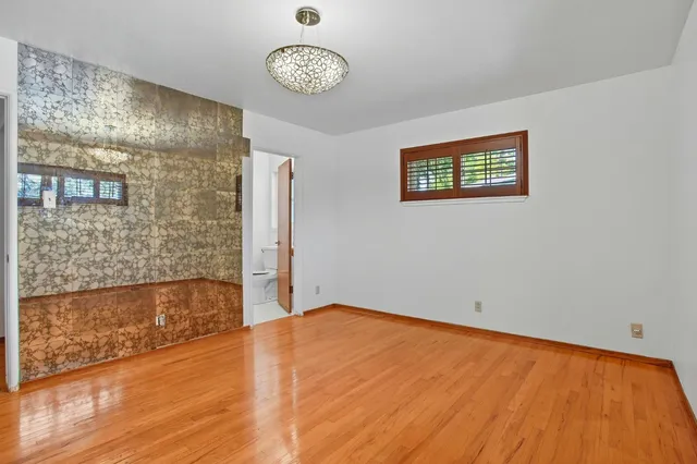 an empty room with a wooden floor and a window