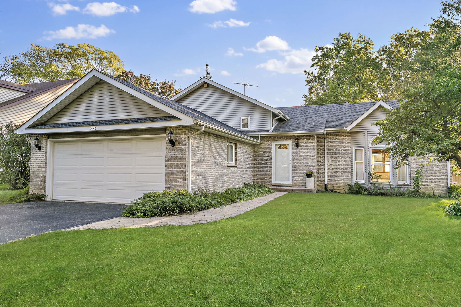 a front view of a house with a garden