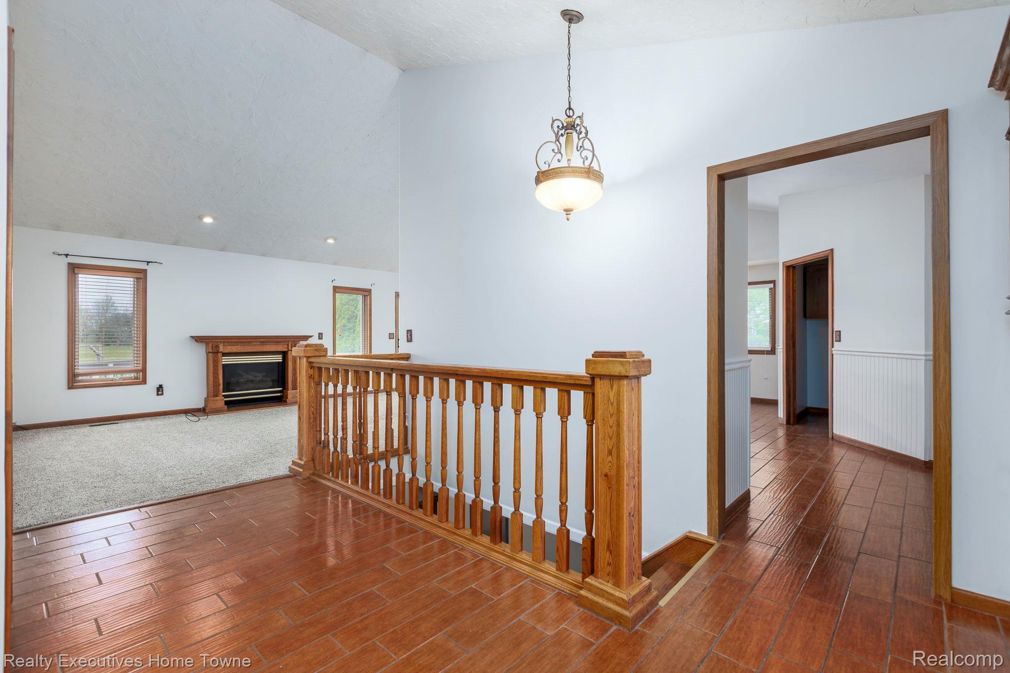 1041 Mackie Road Almont, MI 48003 - Photo 20 of 56 Hall with vaulted ceiling, wood tiled floors, an upstairs landing, and healthy amount of natural light