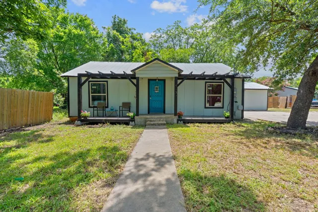 a front view of a house with yard garage and wooden fence