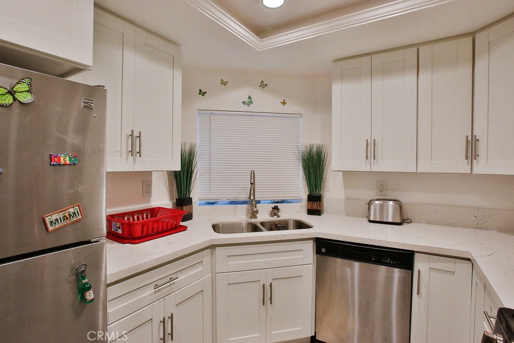 6637 Caro Street Paramount, CA 90723 - Photo 35 of 61 a kitchen with white cabinets and a sink