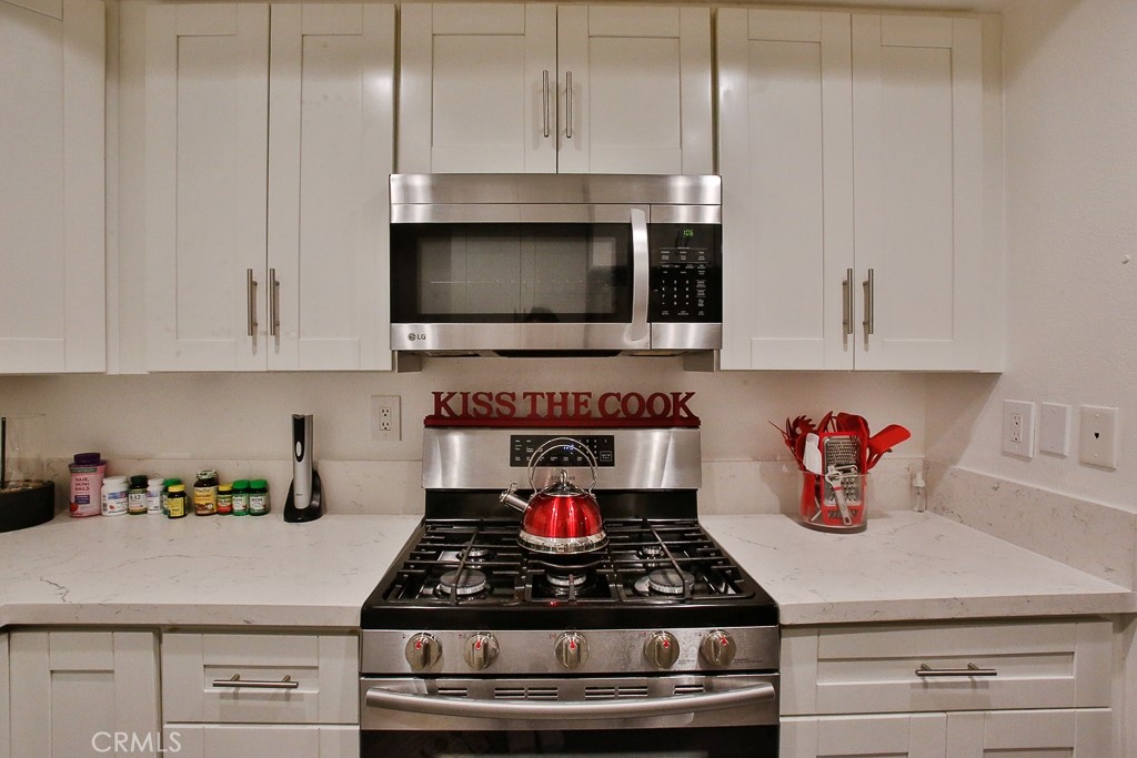 6637 Caro Street Paramount, CA 90723 - Photo 37 of 61 a kitchen with white cabinets and a stove top oven