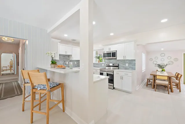 a kitchen with white cabinets and stainless steel appliances