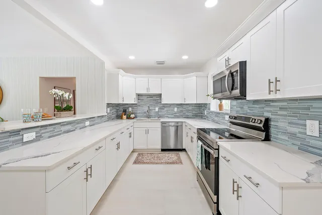 a kitchen with granite countertop white cabinets and white appliances