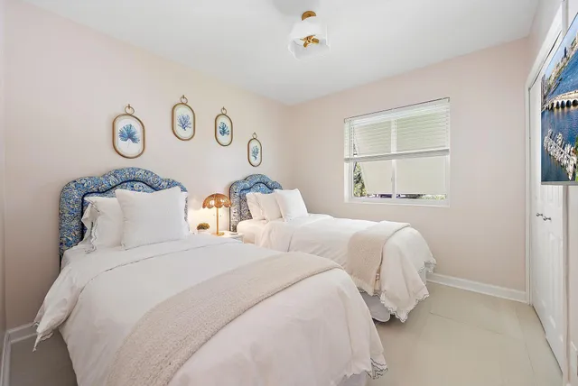 a bedroom with two beds and a window