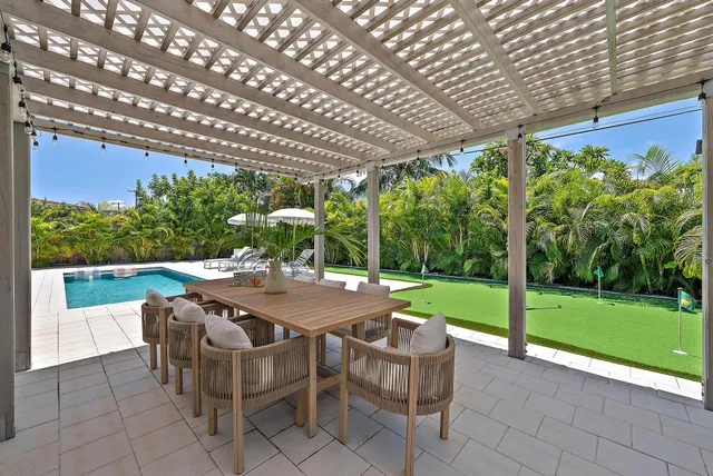 a view of a patio with a table chairs and a backyard