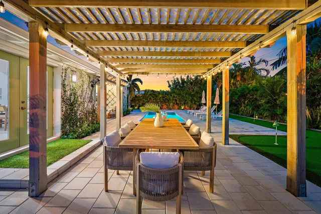 a swimming pool with lawn chairs and wooden fence