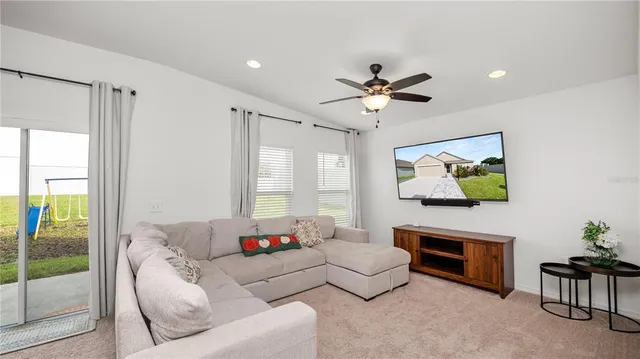 a living room with furniture ceiling fan and a window