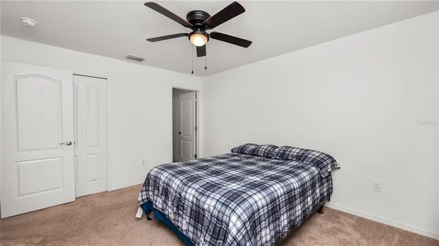 a bedroom with a bed and a ceiling fan