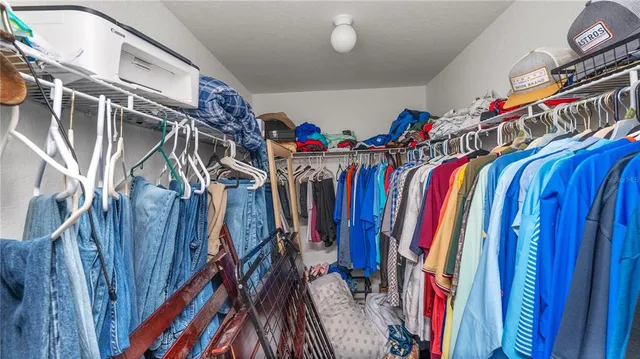 a view of walk in closet with clothes