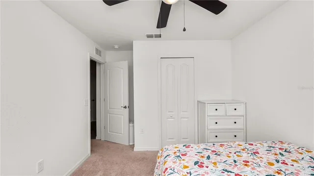 a bedroom with a dresser and a chandelier