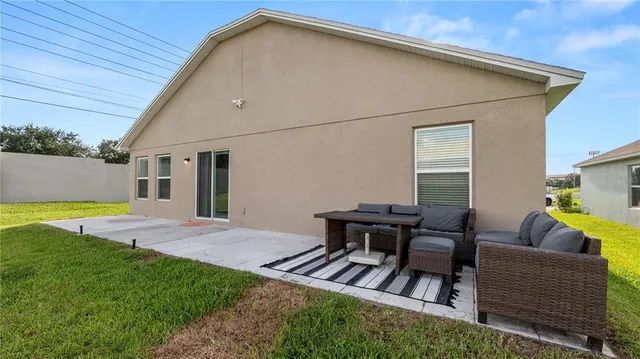 a view of backyard of house with outdoor seating