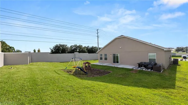 a backyard of a house with table and chairs