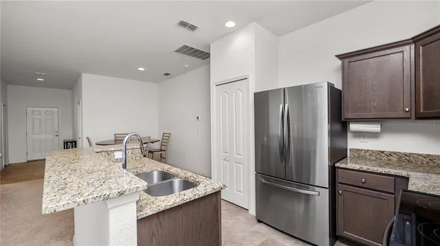 a kitchen with stainless steel appliances granite countertop a refrigerator and a sink