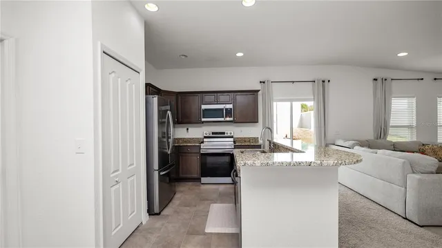 a large kitchen with cabinets in it and stainless steel appliances
