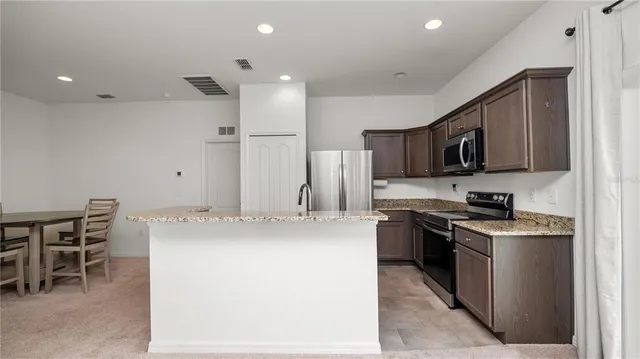 a kitchen with kitchen island a stove sink and microwave