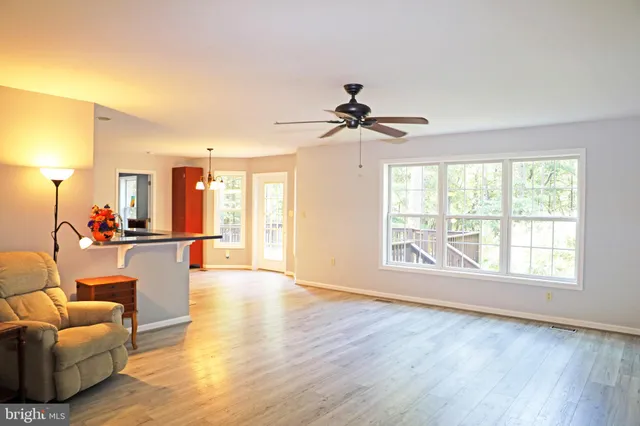 a room with wooden floor and a chandelier fan