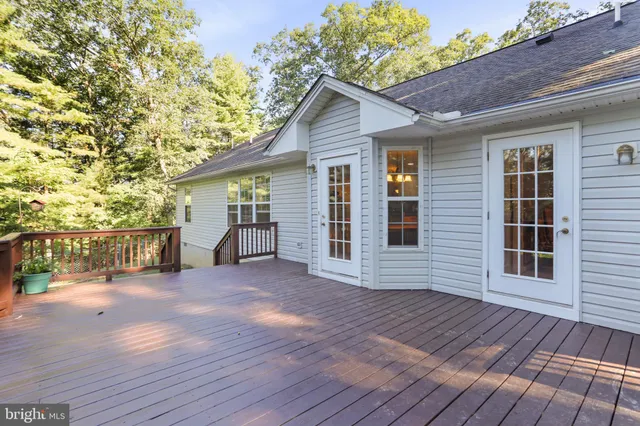 a view of kitchen with stainless steel appliances refrigerator stove and wooden floor
