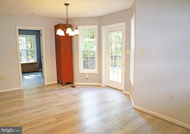 an empty room with windows and cabinet