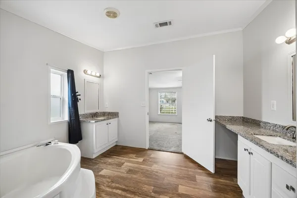 a spacious bathroom with a granite countertop tub sink and mirror
