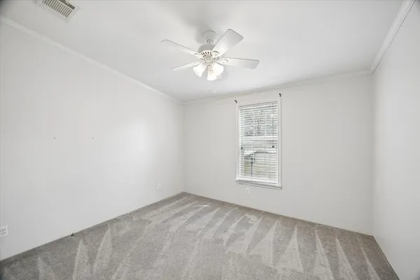 an empty room with a window and a fan