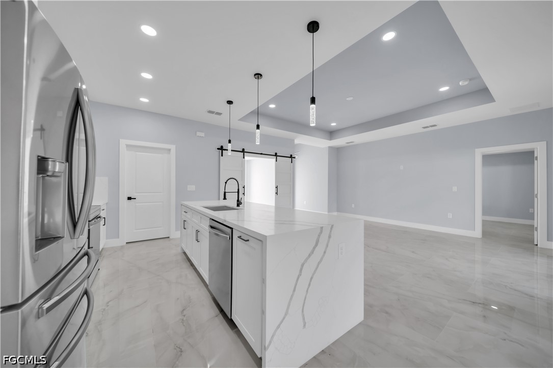 4028 26th Street Southwest Lehigh Acres, FL 33976 - Photo 13 of 38 a large kitchen with a sink and stainless steel appliances
