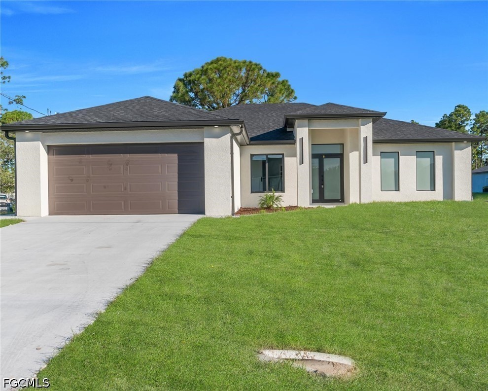 4028 26th Street Southwest Lehigh Acres, FL 33976 - Photo 2 of 38 a front view of a house with a garden and yard