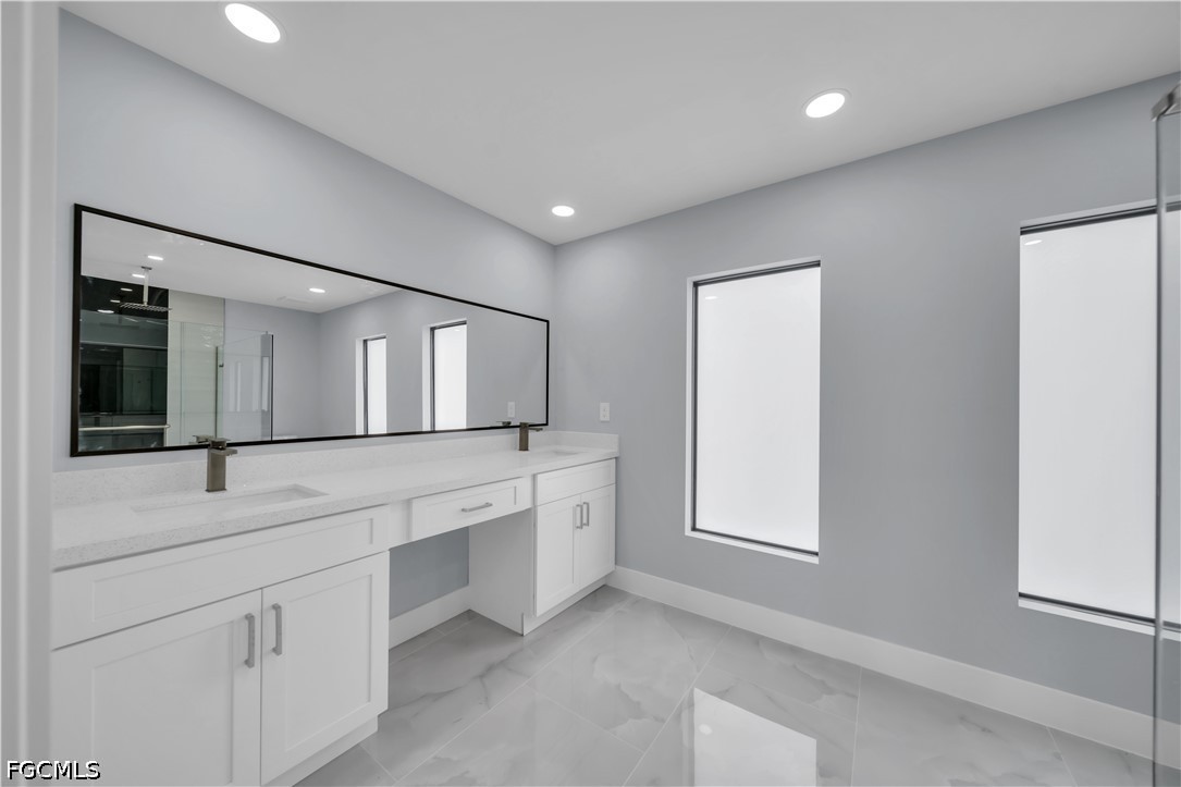 4028 26th Street Southwest Lehigh Acres, FL 33976 - Photo 26 of 38 a bathroom with a double vanity sink and mirror with window