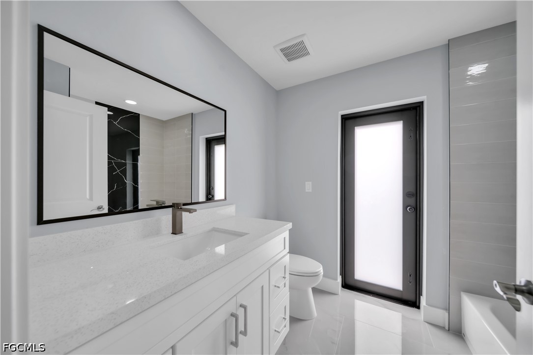 4028 26th Street Southwest Lehigh Acres, FL 33976 - Photo 32 of 38 a bathroom with a sink and a mirror