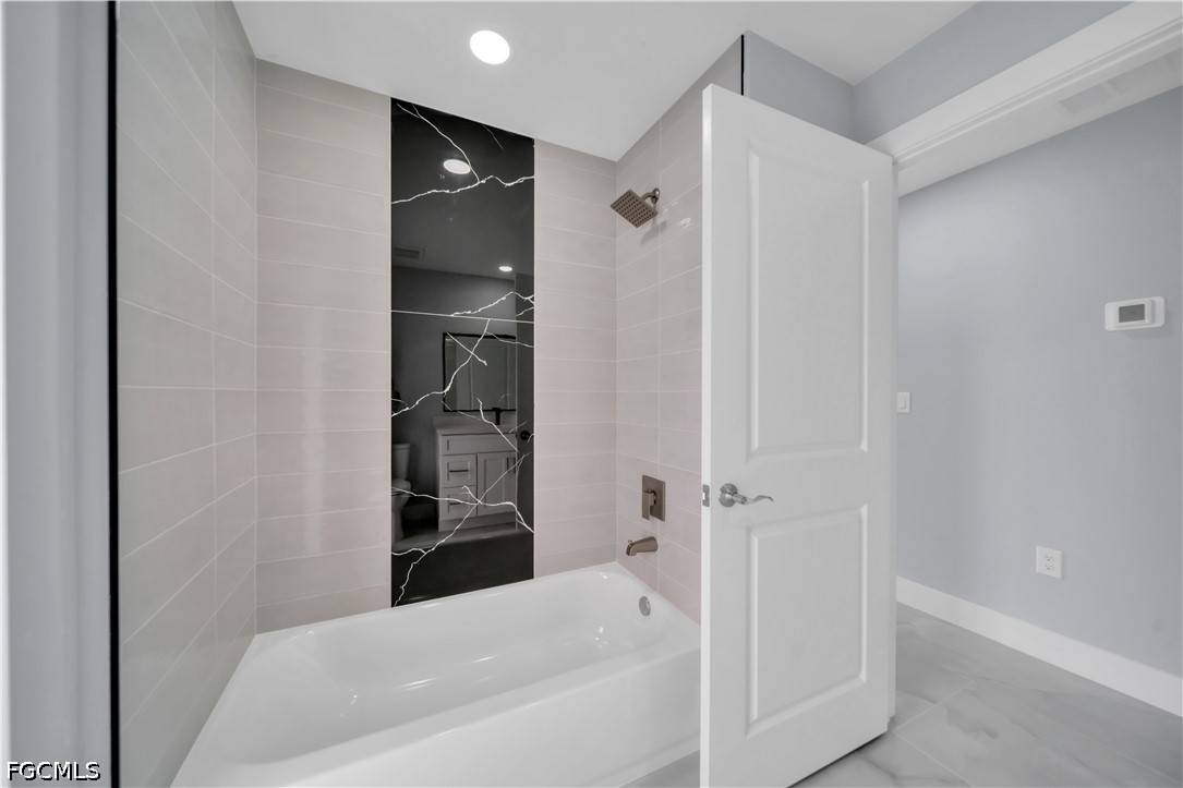 4028 26th Street Southwest Lehigh Acres, FL 33976 - Photo 34 of 38 a bathroom with a bathtub and shower