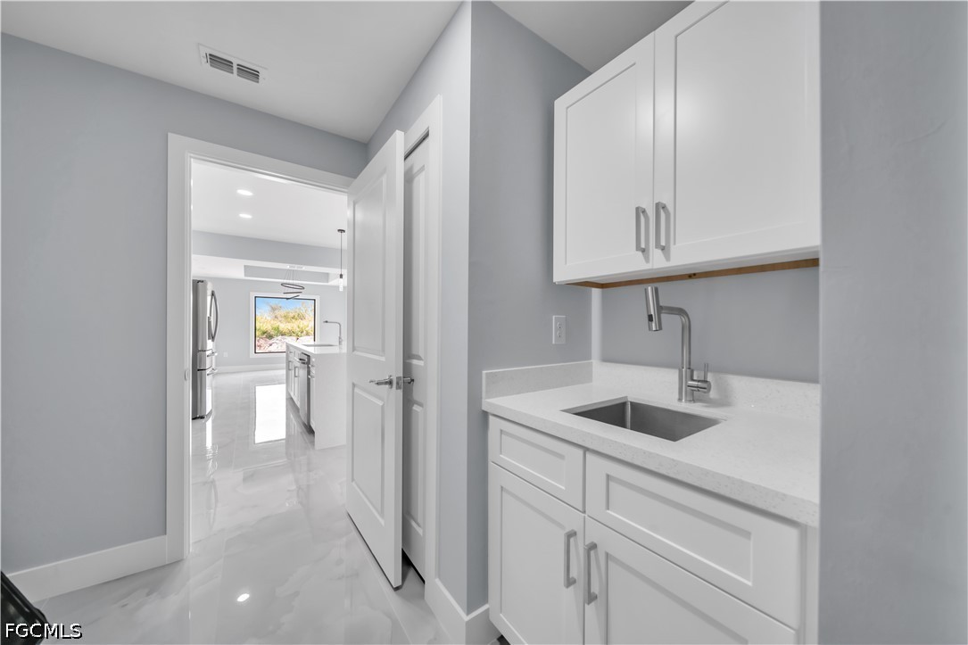 4028 26th Street Southwest Lehigh Acres, FL 33976 - Photo 35 of 38 a kitchen with cabinets and a sink
