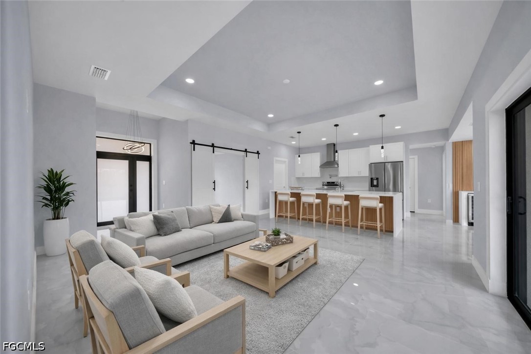 4028 26th Street Southwest Lehigh Acres, FL 33976 - Photo 5 of 38 a living room with couches and kitchen view with wooden floor