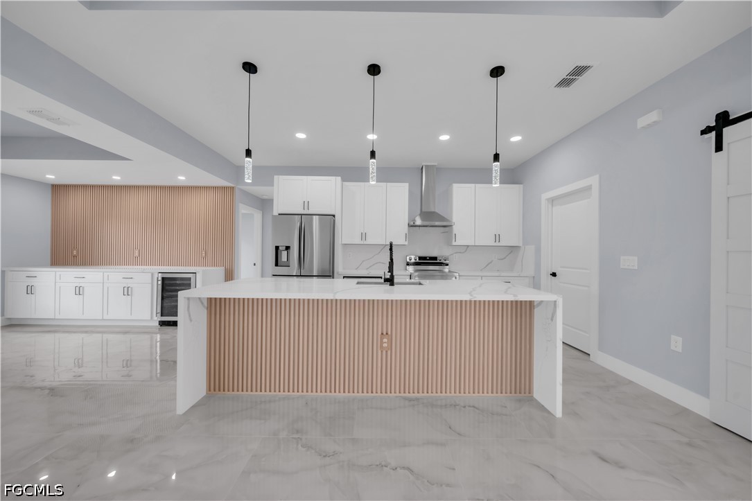 4028 26th Street Southwest Lehigh Acres, FL 33976 - Photo 6 of 38 a view of kitchen with kitchen island a sink stainless steel appliances and a refrigerator