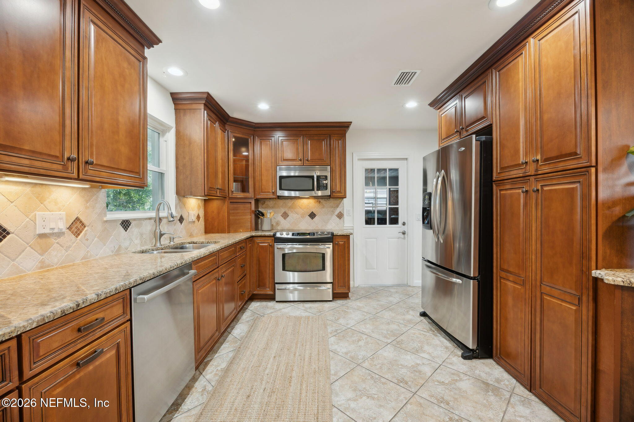 600 Davis Street Neptune Beach, FL 32266 - Photo 5 of 33 a large kitchen with cabinets and stainless steel appliances