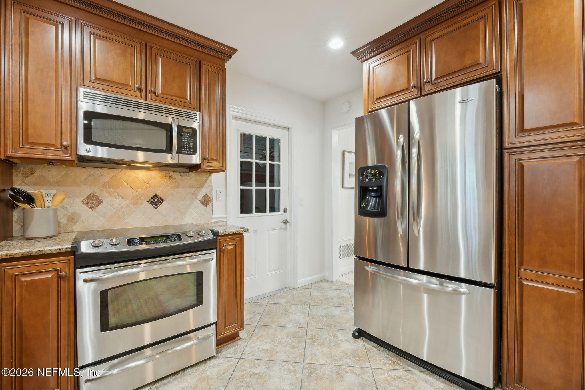 600 Davis Street Neptune Beach, FL 32266 - Photo 6 of 33 a kitchen with stainless steel appliances granite countertop a refrigerator stove and microwave
