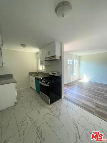 a large kitchen with a stove a sink and a refrigerator