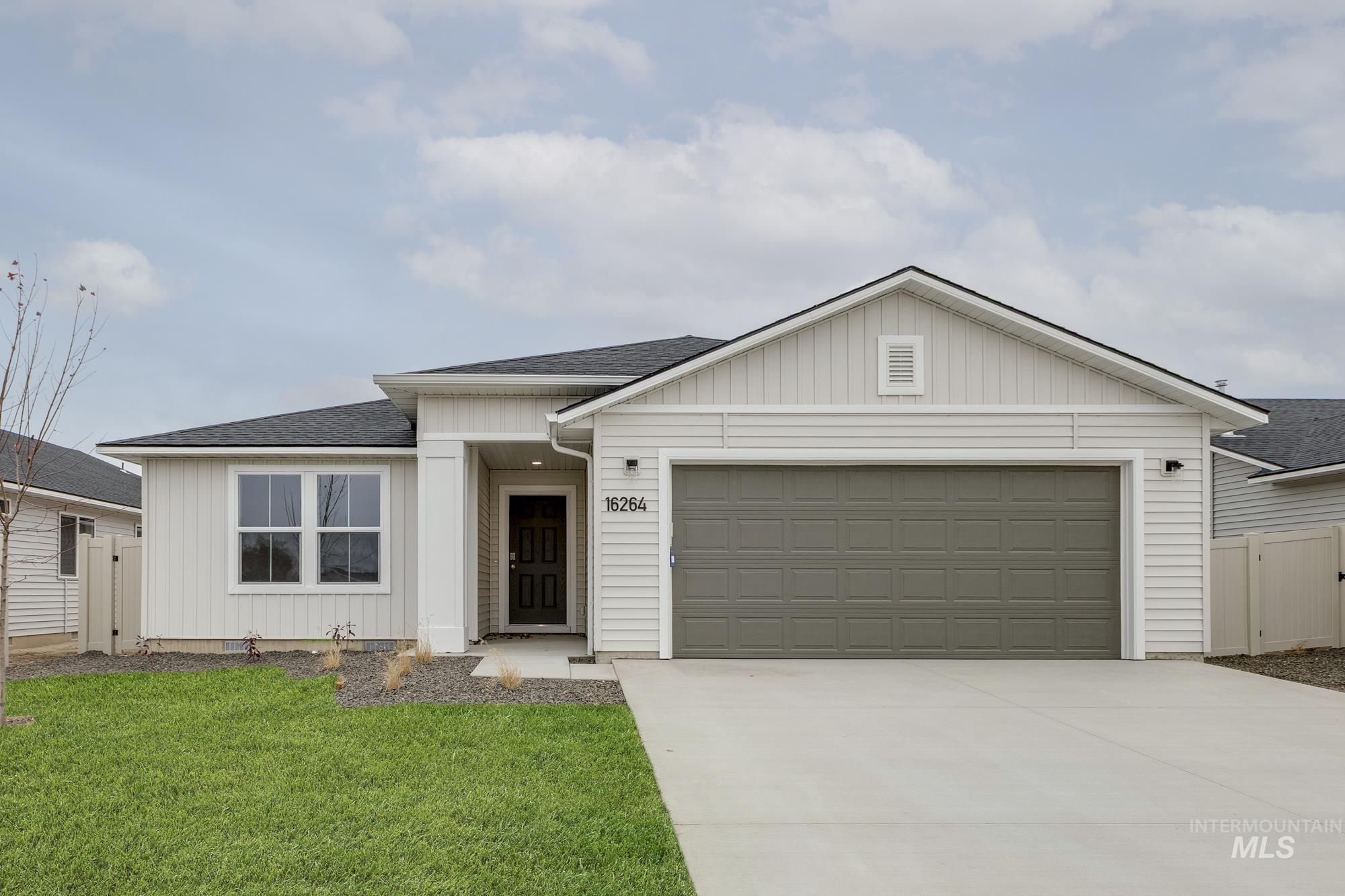 Ranch-style home with a shingled roof, board and batten siding, driveway, and a garage