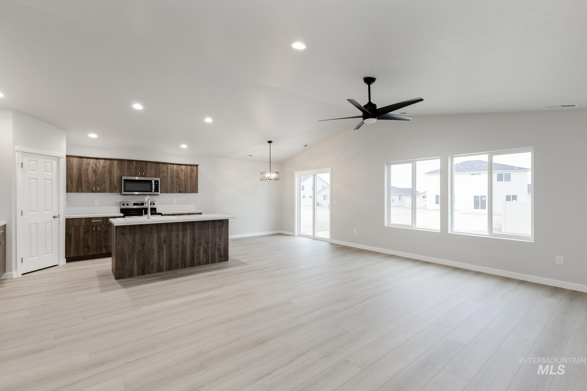 16264 Fill Avenue Caldwell, ID 83607 - Photo 18 of 18 Kitchen with an island with sink, open floor plan, dark brown cabinets, recessed lighting, and stainless steel appliances
