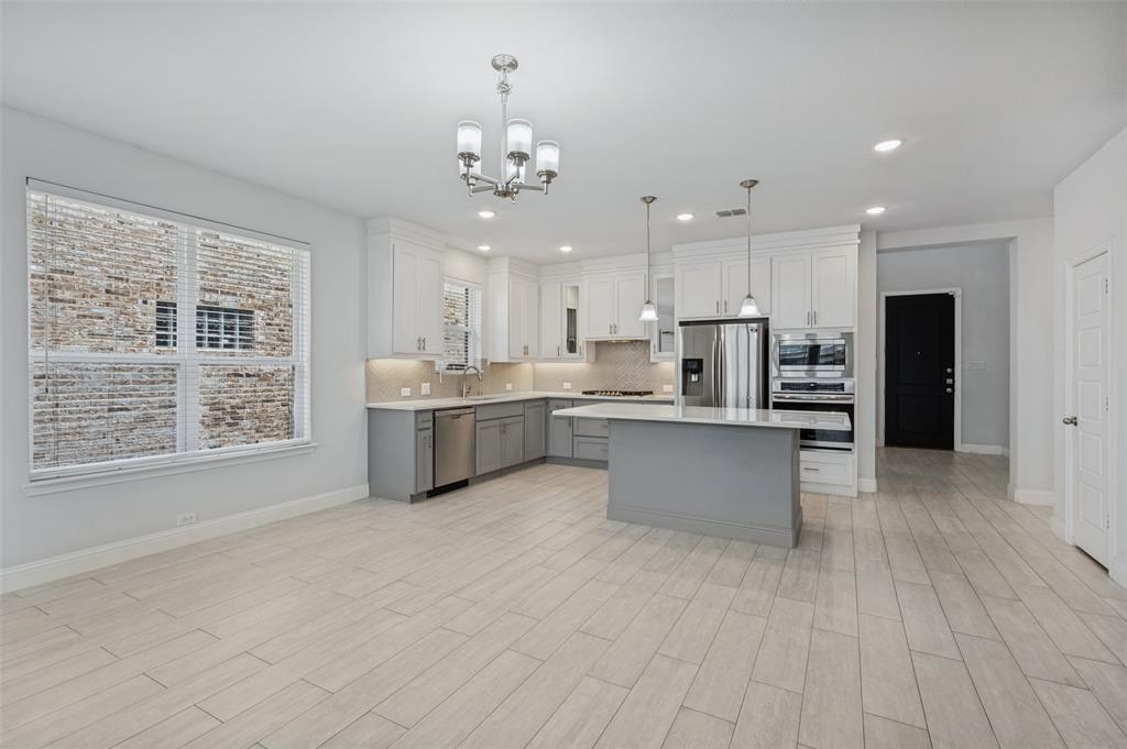 15862 Shasta Daisy Road Frisco, TX 75035 - Photo 2 of 15 Open-concept kitchen with a central island, ceramic tile flooring, recessed lighting, and stainless steel appliances. Room for large dining table. Pantry door to right.