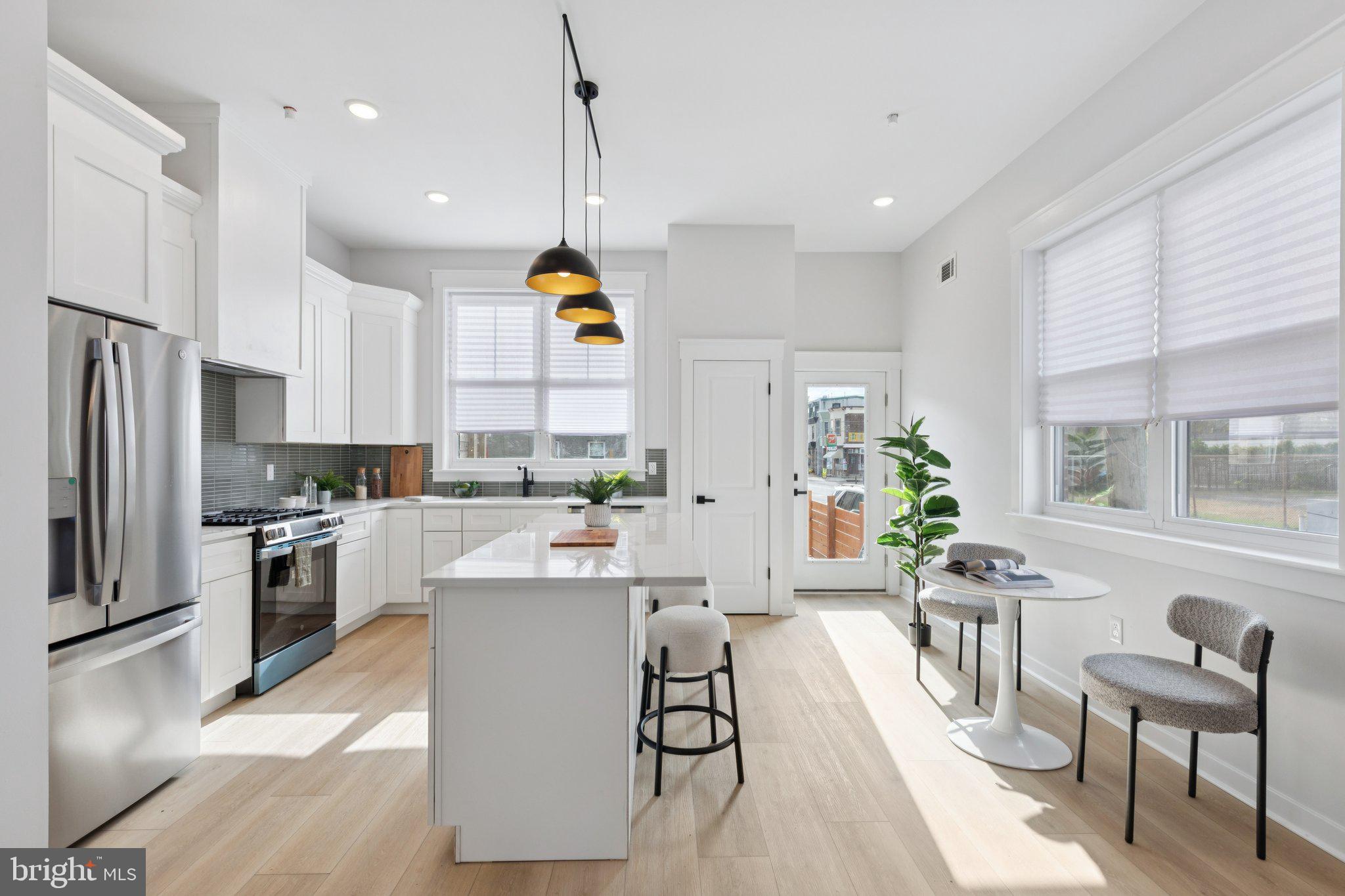 2800 Bridge Street Philadelphia, PA 19137 - Photo 14 of 51 a kitchen with stainless steel appliances kitchen island granite countertop a sink a stove a refrigerator cabinets and chairs