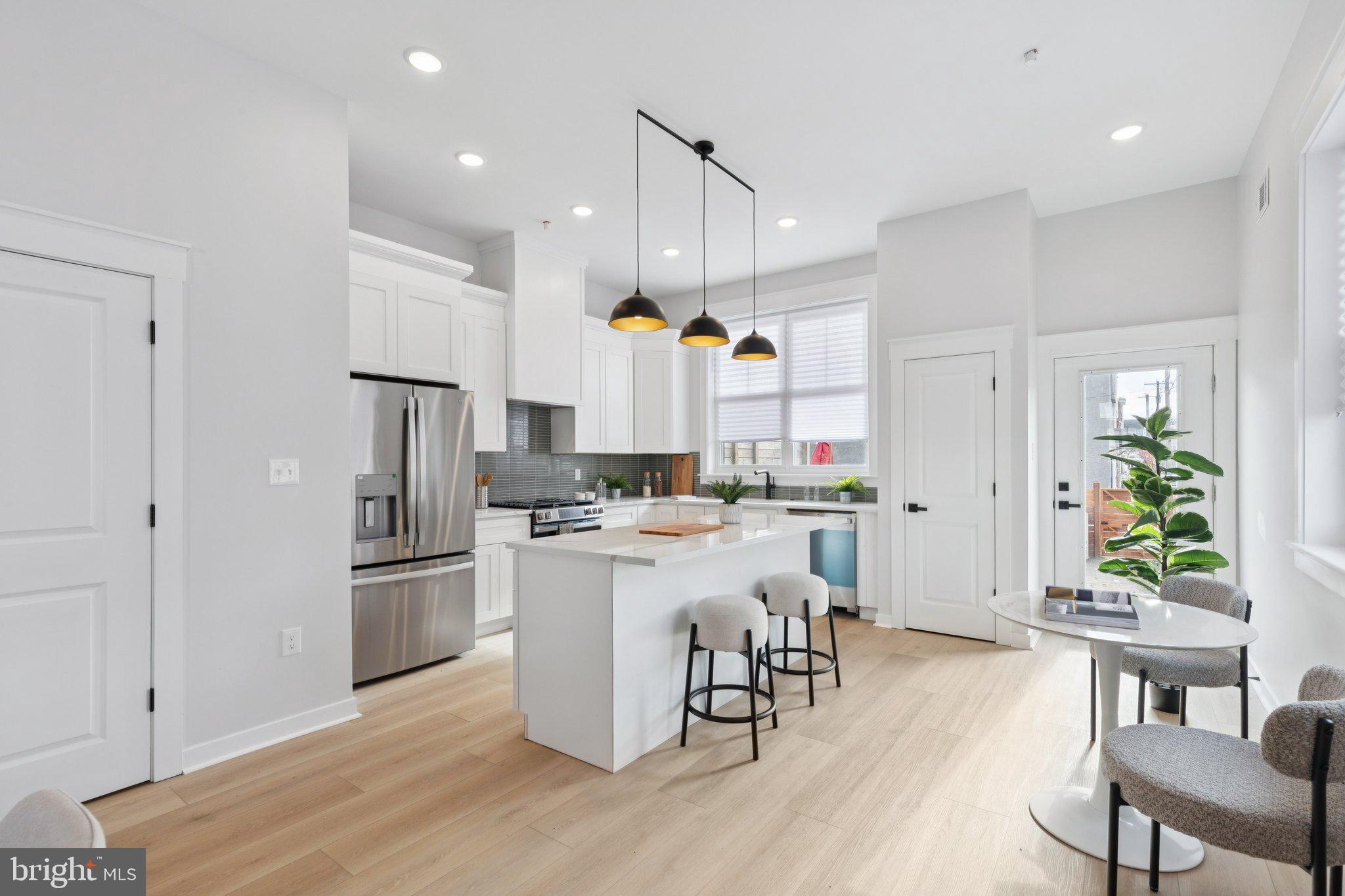 2800 Bridge Street Philadelphia, PA 19137 - Photo 16 of 51 a kitchen with stainless steel appliances kitchen island granite countertop a refrigerator a stove a sink a dining table and chairs with wooden floor
